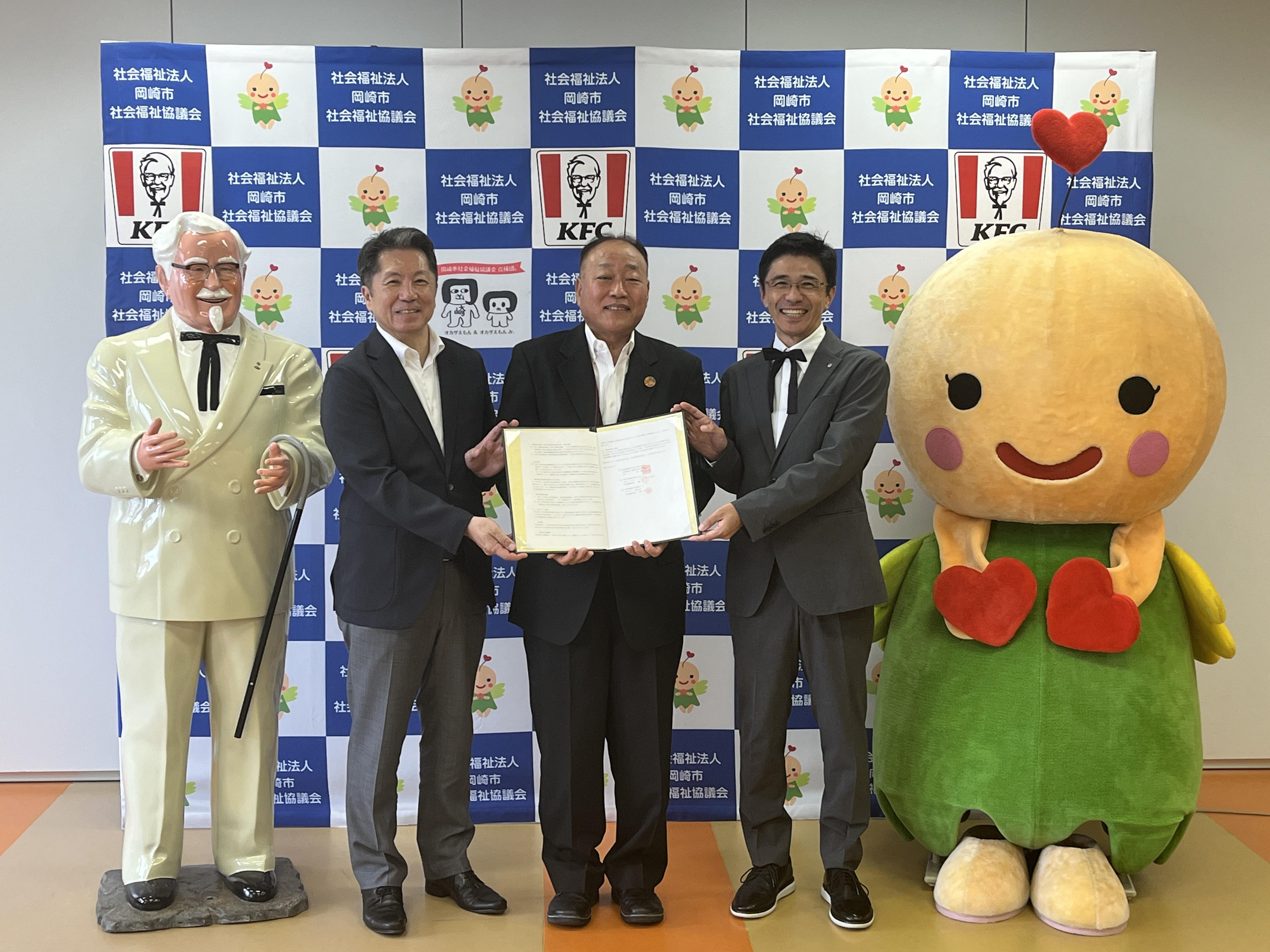 左からカーネル立像、日本KFC 遠藤、岡崎市社会福祉協議会 太田会長、タニザワフーズ 谷澤社長、はぴりん